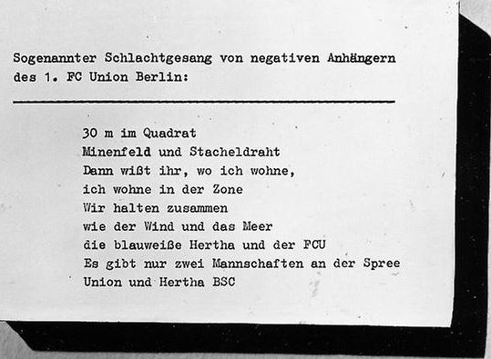  "Chants de guerre entonnés par les supporters négatifs du 1. FC Union Berlin : "30m², champ de mines et Rideau de Fer, vous savez donc où j'habite, j'habite dans la Zone" - "Nous nous dressons ensemble, comme le vent et la mer, le Hertha BSC bleu et blanc, et le FCU", "Il n'y a que deux équipes sur les bords de la Spree : l'Union et le Hertha BSC"" (traductions de l'auteur, (c) Archives de la Stasi)